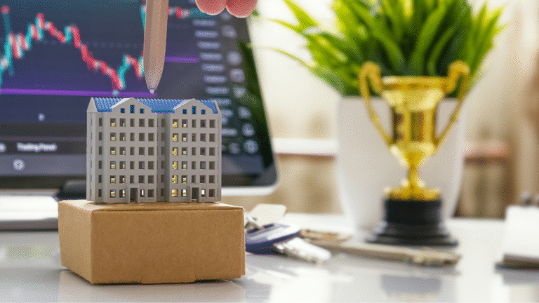 Wieżowiec z tektury na tle monitor z giełdą papierów wartościowych